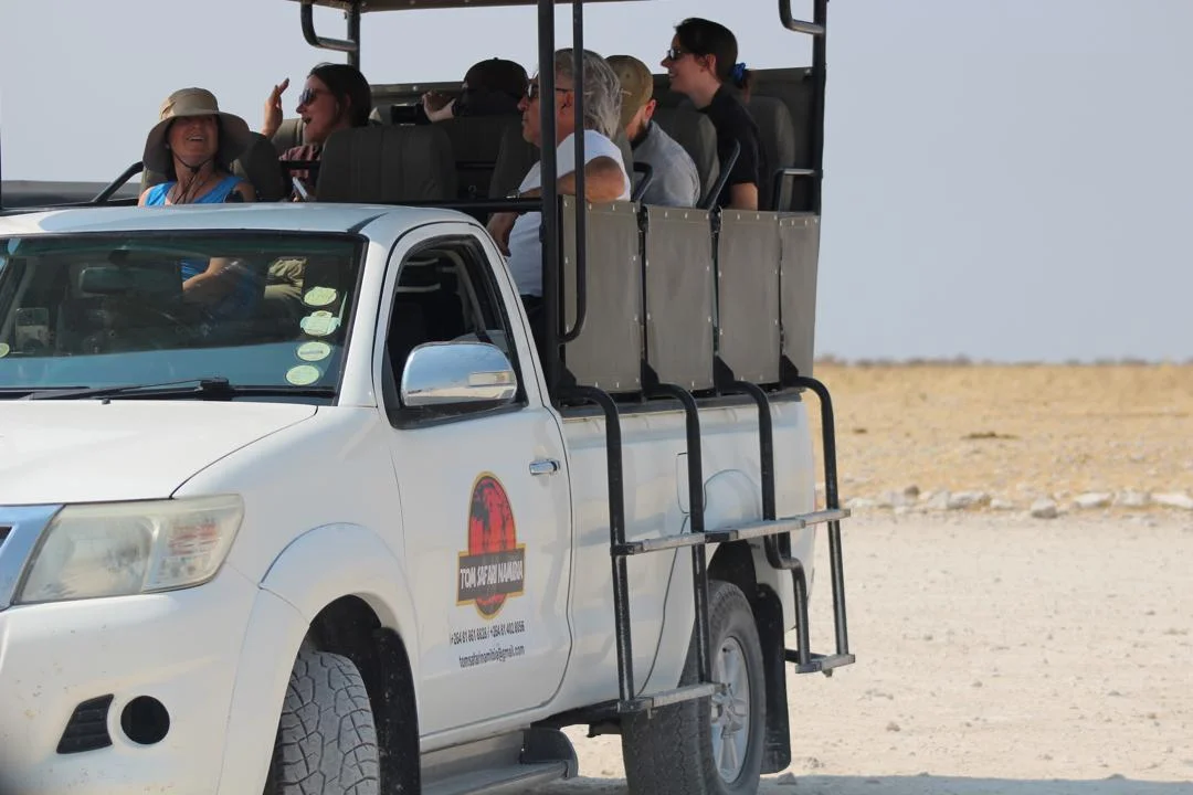 Turisti su veicolo safari aperto nel Parco Nazionale di Etosha con Tom Safari Namibia